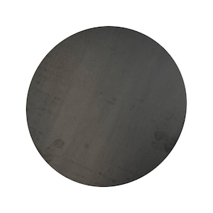 May include: A large, circular, dark gray metal disc with a slightly textured surface. The disc has a matte finish and appears to be made of a solid material. The edges are smooth and rounded. The overall appearance is industrial and minimalist.