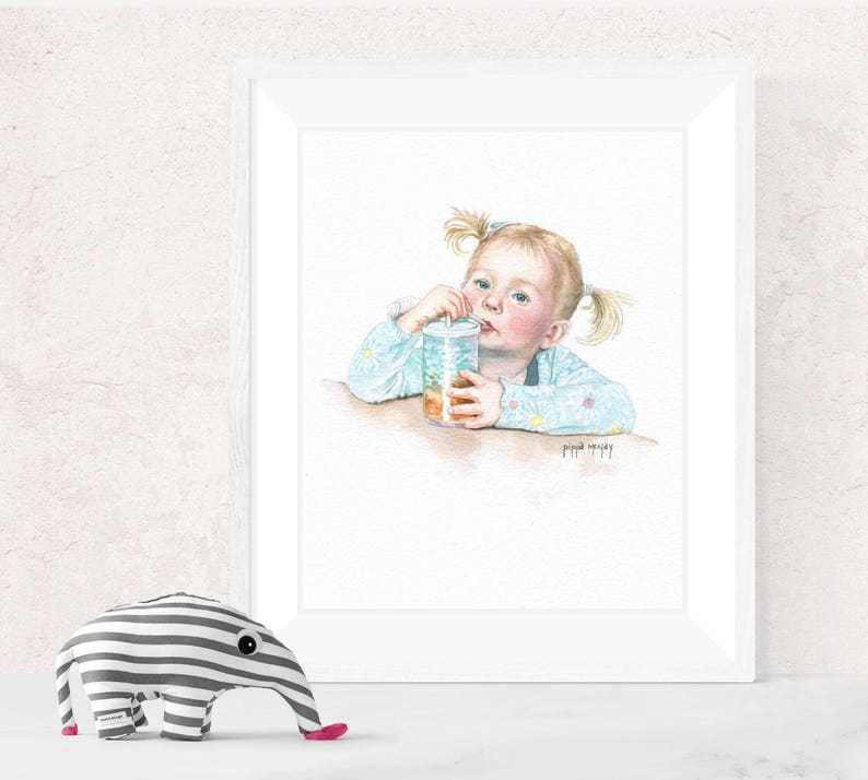 May include: A watercolor painting of a young girl with blonde hair, wearing a light blue shirt with white polka dots, drinking from a glass with a straw. The painting is framed in a white frame.