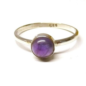 May include: A silver ring featuring a purple amethyst gemstone. The ring is hallmarked with the number "925" on the inside band.