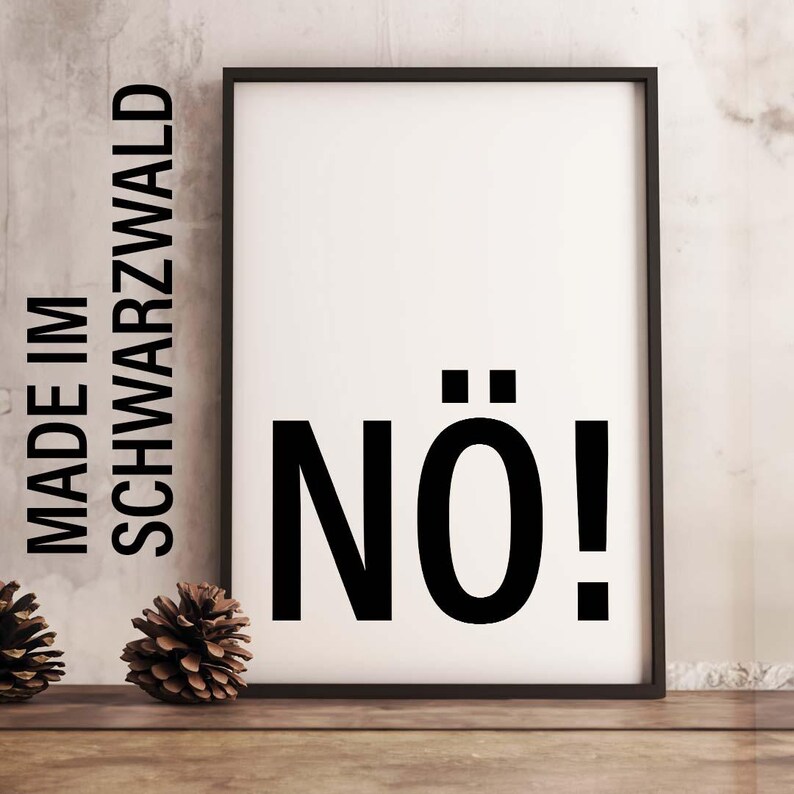 May include: A black framed poster with white background and the text "MADE IM SCHWARZWALD" on the left side and "N&Ouml;!" in bold black letters on the right side.