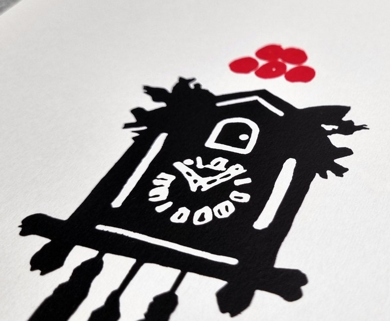 May include: Black and white illustration of a cuckoo clock with a red circle design above it. The clock face has a simple design with black hands and white numbers.