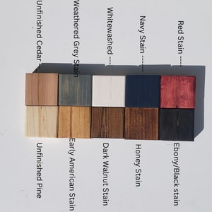 Op de afbeelding: Een verzameling houtbeitsstalen in een raster, met kleuren als Unfinished Cedar, Weathered Grey Stain, Whitewashed, Navy Stain en Red Stain. De afbeelding toont de verschillende afwerkingen die beschikbaar zijn voor hout.
