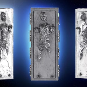 K&ouml;nnte beinhalten: Drei silberfarbene, rechteckige Skulpturen, die eine in einem Block gefrorene Person darstellen. Die Skulpturen haben ein detailliertes Relief einer Person in klassischer Pose. Der Hintergrund ist ein Blauton mit Sterneneffekt.