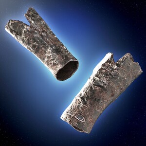 May include: Two pieces of metallic debris, possibly from a spacecraft, floating in space against a dark blue background with stars. The debris is silver and has a rough, textured surface.