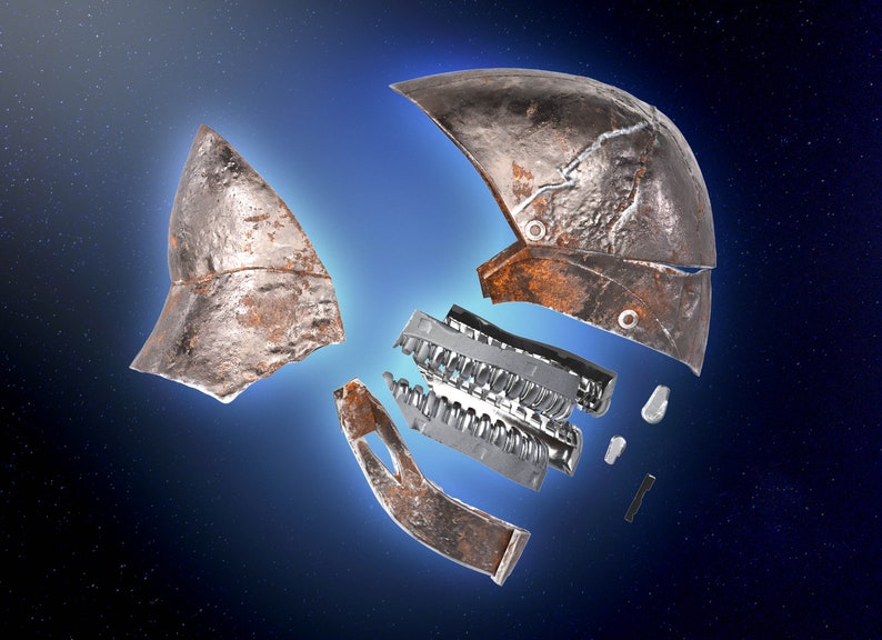 May include: A rusty metal helmet broken into multiple pieces against a dark blue starry background. The helmet is made of metal and has a rough, textured surface. The pieces are scattered around the centre of the image.