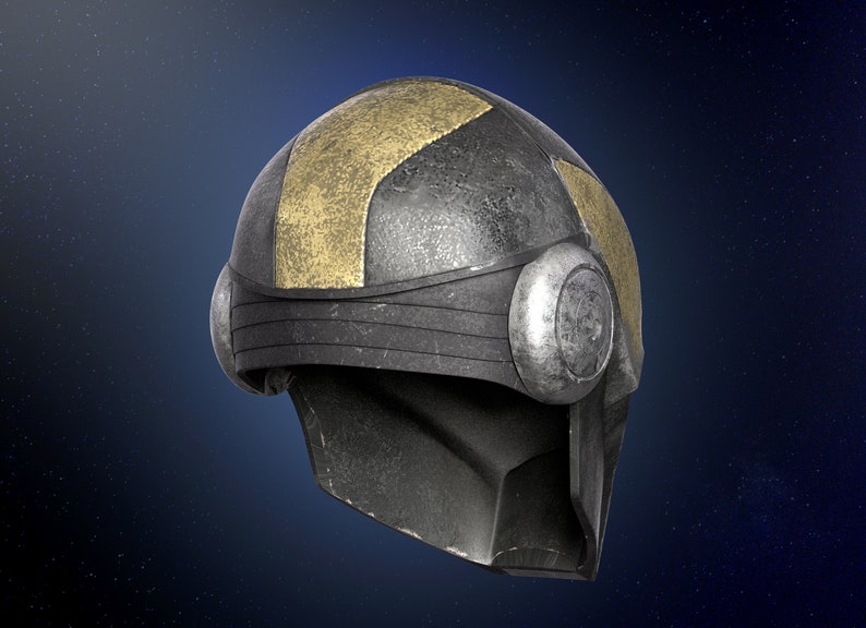 Op de afbeelding: Een verweerde, zilveren helm met een gouden streep en ronde accenten. De helm heeft een vizier en een getextureerd oppervlak.