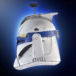 May include: A white and blue helmet with a weathered appearance, featuring a blue band and yellow accents. The helmet has a rectangular antenna and is set against a blue background with a starry effect. The helmet is a replica of a Star Wars clone trooper helmet.