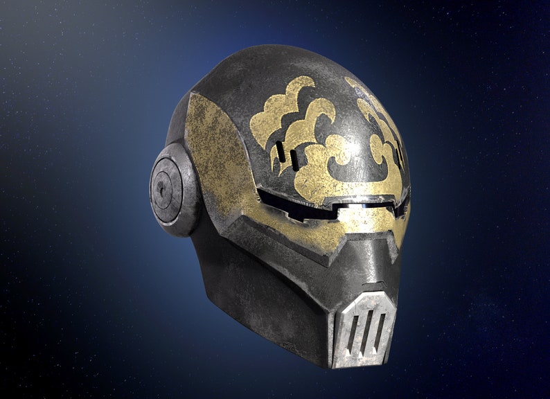 Op de afbeelding: Een zwarte en gouden helm met een gestileerd ontwerp. De helm heeft een vizier en een kinbeschermer.