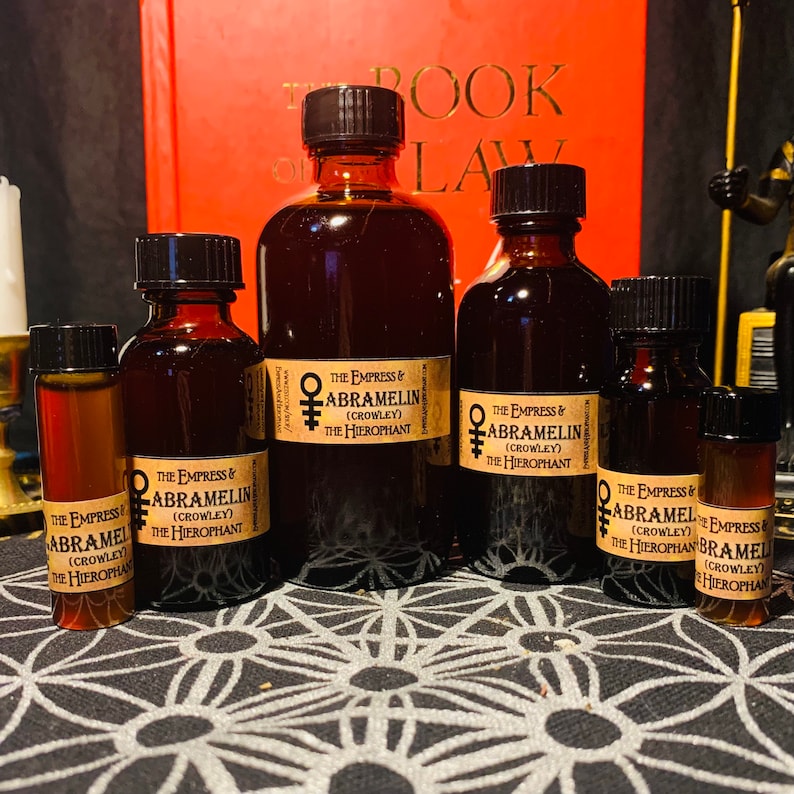 Puede incluir: Cinco botellas de vidrio &aacute;mbar con etiquetas que dicen "The Empress & Abramelin (Crowley) The Hierophant". Las botellas est&aacute;n dispuestas en una fila sobre una superficie con un patr&oacute;n blanco y negro.
