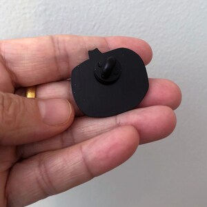 May include: Black enamel pumpkin pin with a silver pin back.