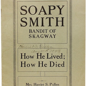 Puede incluir: Una portada de libro vintage con una ilustración en blanco y negro de un hombre con bigote y sombrero. El título es "Soapy Smith, Bandit of Skagway" y el subtítulo es "How He Lived; How He Died" por la Sra. Harriet S. Pullen.