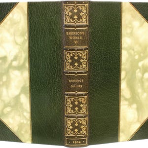 Puede incluir: Un libro antiguo titulado "Emerson's Works VI Conduct of Life" con una cubierta de cuero verde oscuro. El lomo es marr&oacute;n con letras doradas y elementos decorativos. El a&ntilde;o "1904" est&aacute; impreso en la parte inferior.