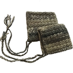 Può includere: Due piccole borse all'uncinetto con lunghi cordoni intrecciati. Le borse sono realizzate in filato beige e grigio con un motivo a righe.