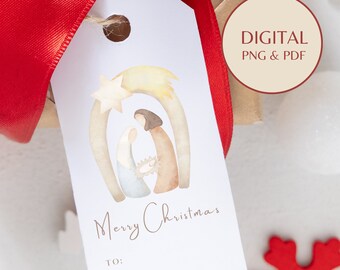 Può includere: Un'etichetta regalo bianca con un'illustrazione ad acquerello della scena della Natività, una stella e una cometa. Le parole "Merry Christmas" sono scritte in corsivo. L'etichetta è legata con un nastro rosso.