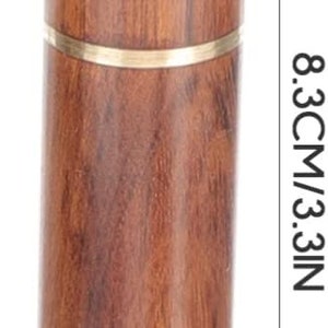 May include: A cylindrical wooden toothpick holder, 3.3 inches tall and 0.7 inches wide, with a brass band. The holder has a rounded top and a natural wood grain finish.