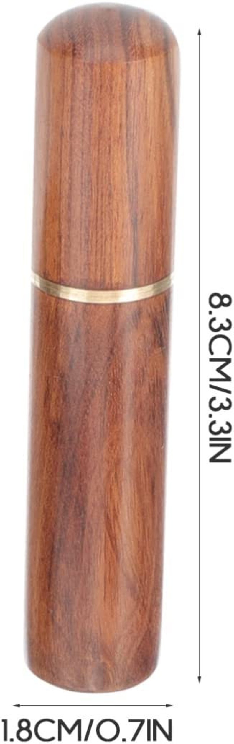 May include: A cylindrical wooden toothpick holder, 3.3 inches tall and 0.7 inches wide, with a brass band. The holder has a rounded top and a natural wood grain finish.
