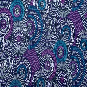 May include: A purple and blue fabric with a repeating pattern of white circles with concentric rings. The circles are arranged in a random pattern.
