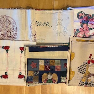 May include: Assortment of fabric pieces with various designs. Includes a floral pattern, a cardinal bird, a patchwork design, a bear illustration, and a bear made of floral fabric. Some pieces have text, including "BEAR" and "HENRIET".