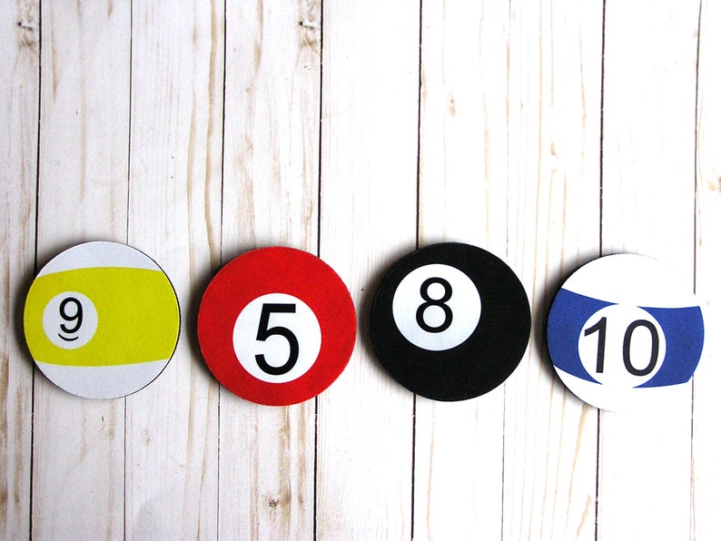 May include: Four round pool ball coasters with numbers 9, 5, 8, and 10. The coasters are yellow, red, black, and blue.