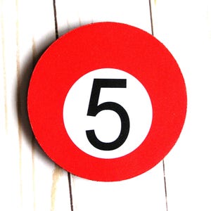May include: A red circle with a white circle inside, containing the number 5 in black.