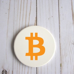 以下が含まれることがあります： オレンジ色のビットコインのシンボルが描かれた白い丸いコースター