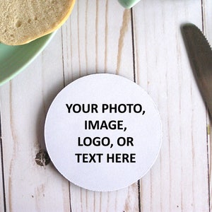 May include: White round coaster with the text "YOUR PHOTO, IMAGE, LOGO, OR TEXT HERE" printed in black.