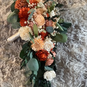 Muted tones and a touch of orange cascading bouquet, sola wood flowers