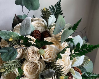 Winter wedding bridal bouquet with ivory sola wood flowers and pine cones