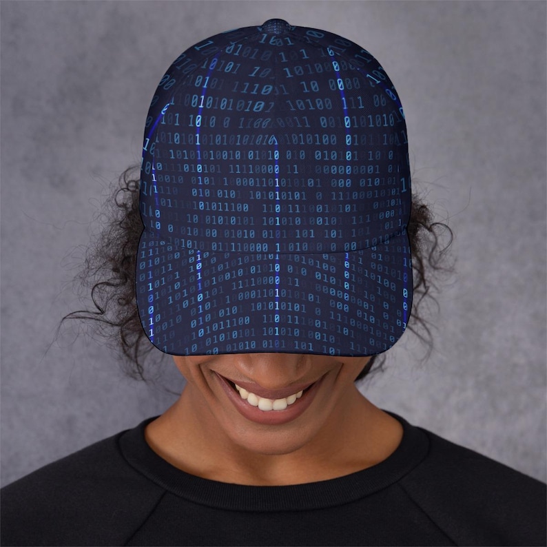 May include: A navy blue baseball cap with a repeating binary code pattern in blue and teal. The cap has a curved peak and a structured crown, offering a modern, tech-inspired aesthetic.