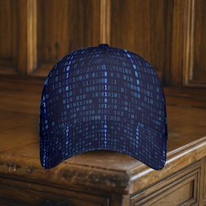 May include: A dark blue baseball cap featuring a binary code pattern in blue hues. The cap is constructed from a robust material and has a curved peak. The hat is presented on a wooden surface.