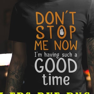 Puede incluir: Una camiseta negra con texto blanco que dice "Don't Stop Me Now I'm having such a Good Time" con un símbolo de mano de parada en naranja. El texto está en negrita, fuente sans-serif.