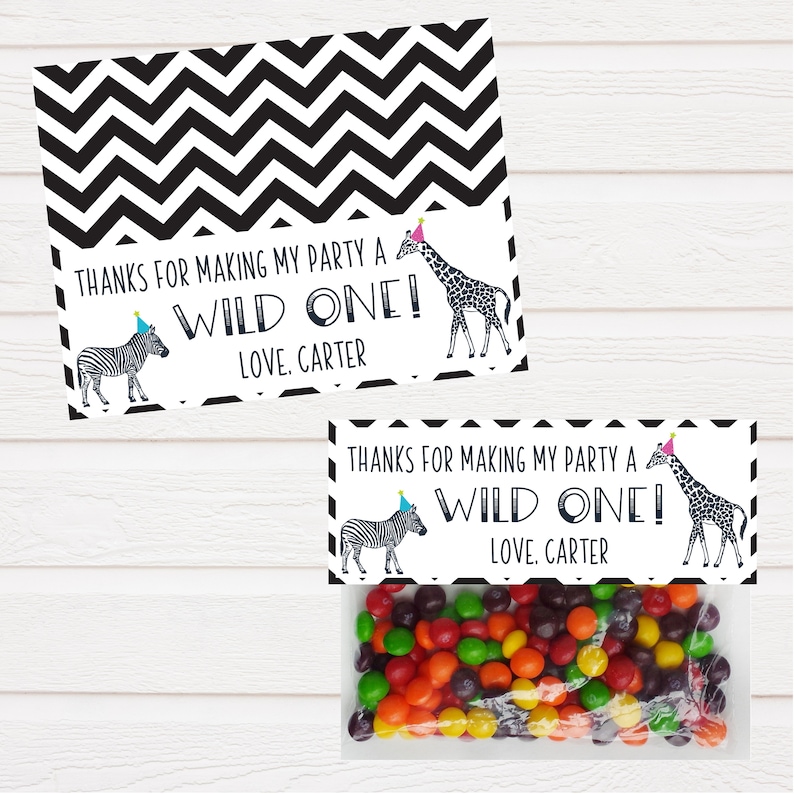 May include: Black and white chevron patterned favour bags with a white tag that says "Thanks for making my party a wild one! Love, Carter" and a zebra and giraffe wearing party hats.