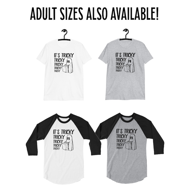 May include: Four t-shirts featuring a ghost holding a bag of sweets and the text "It's Tricky" repeated five times. Two t-shirts are white with black sleeves and two t-shirts are grey with black sleeves.