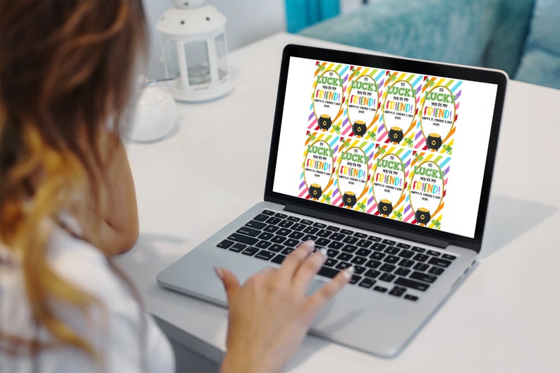 May include: A laptop screen displaying printable gift tags with a rainbow striped background and the text "So lucky you're my friend!" with a pot of gold and shamrock graphic.