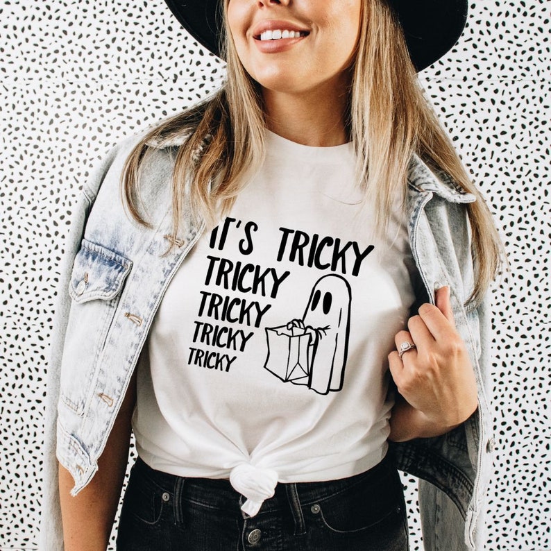 May include: White t-shirt with a black ghost graphic and the text "It's Tricky Tricky Tricky Tricky Tricky" printed on it.