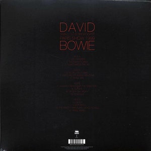 Puede incluir: Portada de disco de vinilo en blanco y negro con el t&iacute;tulo "David Bowie" y el texto "Small Club Broadcast Paris Show 1999" en rojo. La portada del disco enumera la lista de canciones del &aacute;lbum, incluyendo "Something in the Air", "Always Crashing in the Same Car" y "The Pretty Things Are Going to Hell".