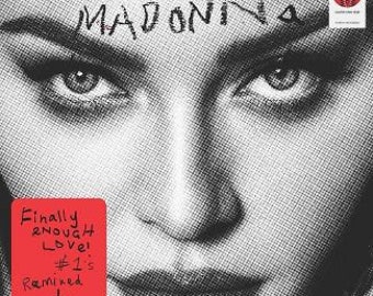 May include: Black and white photo of Madonna with the text "Finally Enough Love! #1's Remixed" in red on a white square.