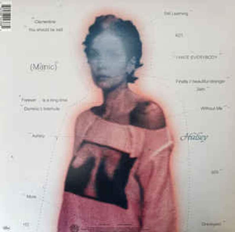 Puede incluir: Una portada de &aacute;lbum de vinilo con una imagen borrosa de una persona con una camiseta rosa. El t&iacute;tulo del &aacute;lbum "(Manic)" es visible, junto con t&iacute;tulos de canciones como "Clementine" y "You should be sad". El fondo es blanco con texto adicional.