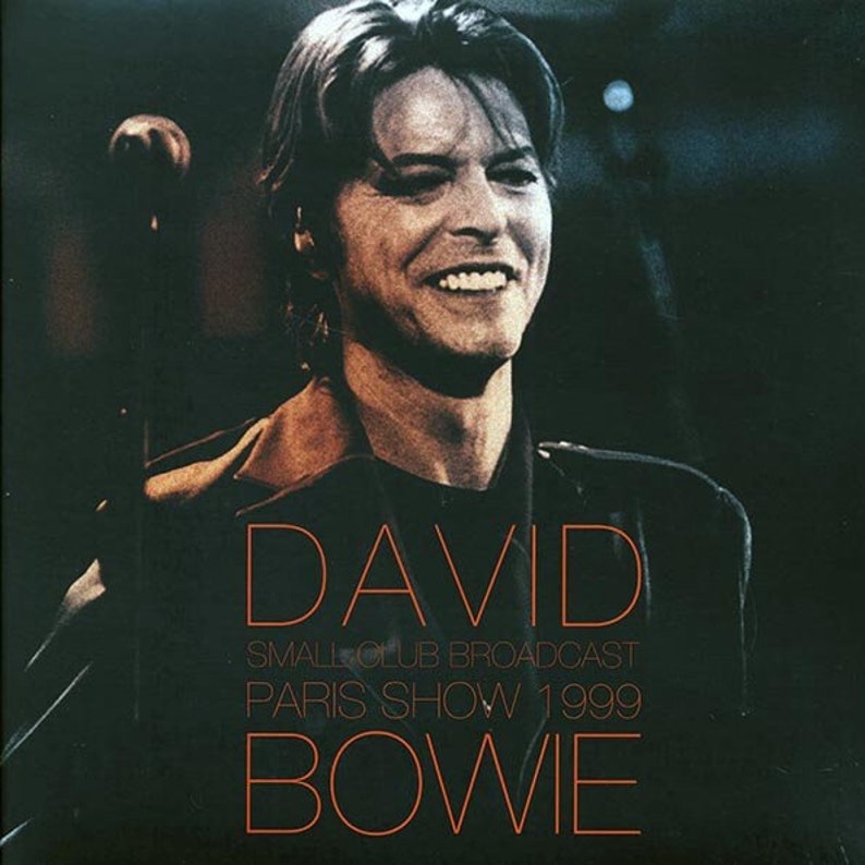Puede incluir: Una imagen en blanco y negro de David Bowie, un m&uacute;sico, con el texto "DAVID SMALL CLUB BROADCAST PARIS SHOW 1999 BOWIE" en naranja.