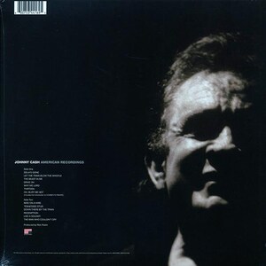 以下が含まれることがあります： ビニールレコードの裏面に写っているジョニー・キャッシュの白黒写真。レコードのタイトルは「American Recordings」で、レコードの両面に収録されている曲がリストされている。