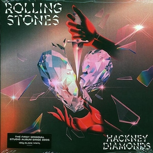 May include: A black and red album cover with a broken diamond heart pierced by a dagger. The album title is "Hackney Diamonds" and the artist is "The Rolling Stones". The text "The First Original Studio Album Since 2005" is also on the cover.