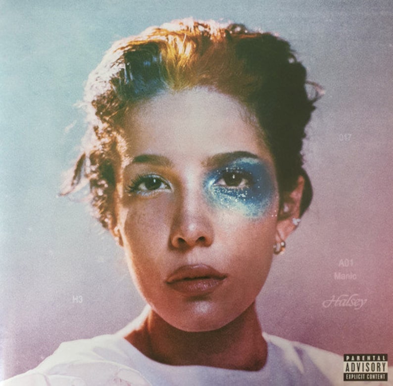 Puede incluir: Portada del &aacute;lbum con un primer plano del rostro de una persona con maquillaje de ojos con purpurina azul. La persona tiene el pelo oscuro con una mecha rubia. El t&iacute;tulo del &aacute;lbum es "Manic" de Halsey, con una advertencia para padres.