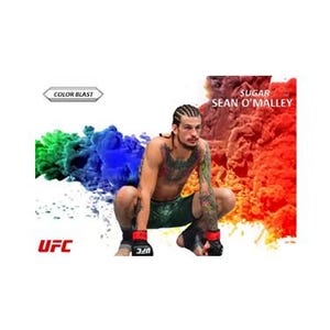 May include: A UFC fighter, Sean O'Malley, known as "Sugar", poses in a fighting stance against a colorful background of red, orange, yellow, green, blue, and purple smoke. The text "UFC" and "COLOR BLAST" are visible in the image.