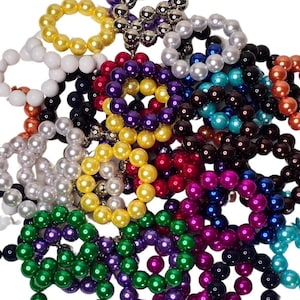 May include: A collection of colorful pearl bracelets in various colors, including white, yellow, green, purple, red, blue, black, and brown.