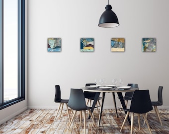 May include: Four square abstract paintings with blue, brown, and yellow hues hang on a white wall. The paintings are above a black dining table with six black chairs. A large window and a black pendant light are also visible.