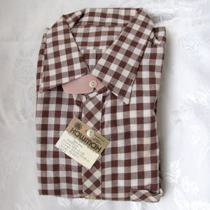 May include: A brown and white gingham button-down shirt with a tag that reads "Hawiman" and "Art. 4914".