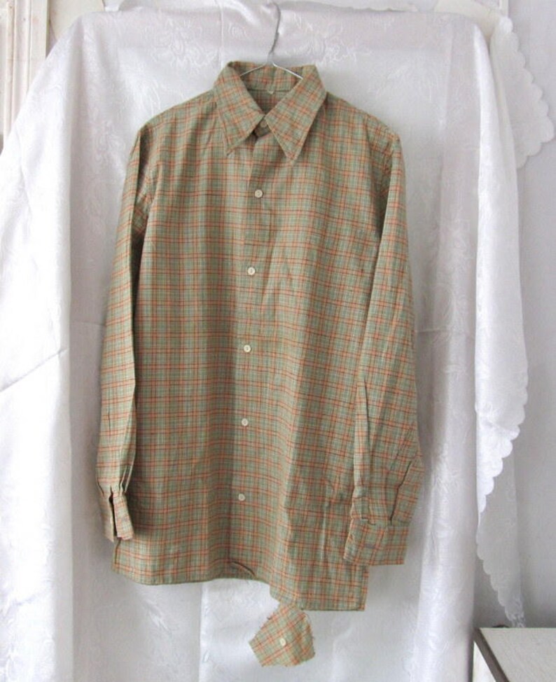 May include: A long-sleeved button-down shirt with a green and orange plaid pattern.