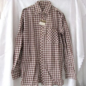 May include: A brown and white gingham long-sleeve button-down shirt with a single chest pocket.