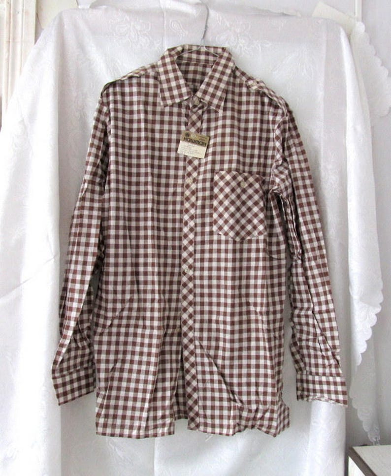 May include: A brown and white gingham long-sleeve button-down shirt with a single chest pocket.
