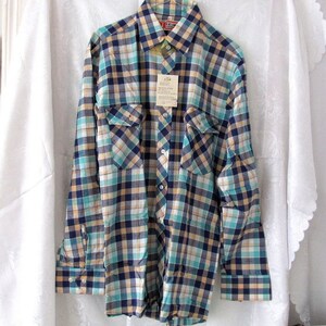 May include: A long-sleeved plaid shirt with a blue, green, yellow, and white checkered pattern. The shirt has two chest pockets and a button-down collar. The shirt has a tag that reads "I.C.M. Industries, Inc."